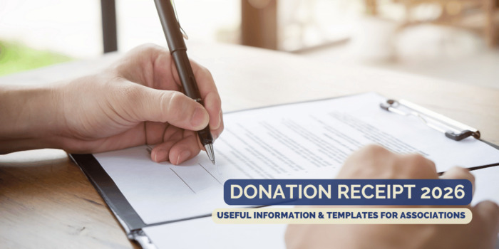 Hand signs a document at the desk with a black ballpoint pen.