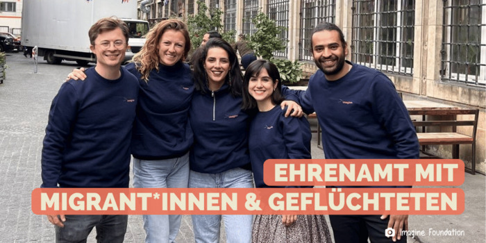 Eine Gruppe aus 5 jungen Menschen unterschiedlicher Hingergründe stehen zusammen und posieren für das Foto